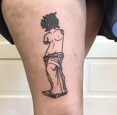 a woman's leg with a tattoo on it that has an image of a statue