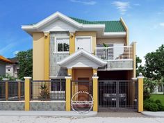 a small house with a green roof and yellow walls