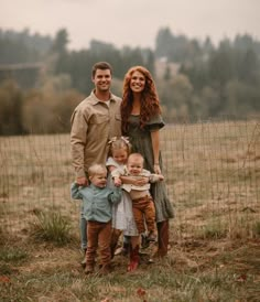 a family posing for a photo in front of a fence