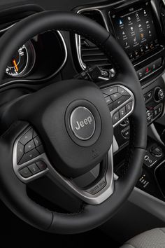 the steering wheel and dashboard of a jeep