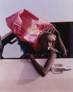 a woman sitting in the back of a car holding an umbrella