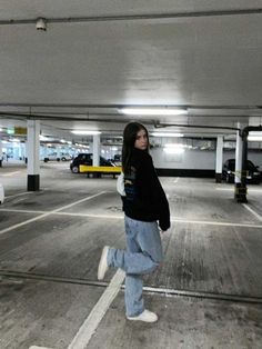 a woman is walking in an empty parking garage