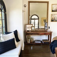 a living room filled with furniture and a large mirror on the wall next to a couch