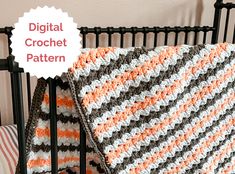 a crocheted blanket sitting on top of a bed next to a black headboard