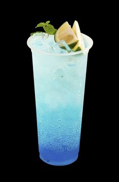 a tall glass filled with blue liquid and lemon wedges