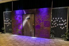 the entrance to an event with purple lighting on it and black curtains over the doors