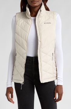 This quilted vest combines thermal reflective technology and plush fill so you'll stay warm to your core on trail walks or strolls through town. A cozy, fleece lined collar brings warmth up close when you need it most and front zip pockets let you carry the essentials. 25" length Front zip closure Stand collar Water repellent Front zip pockets Lined, with polyester fill 100% polyester Machine wash, tumble dry Imported Winter Hiking Vest With Fleece Lining, Winter Hiking Vest Outerwear, Winter Hiking Outerwear Vest, Quilted Winter Vest For Outdoor, Quilted Winter Outdoor Vest, White Sleeveless Outdoor Outerwear, Outerwear Vest, Quilted Vest, Outerwear Women