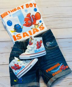 a pair of blue jean shorts with finding nemo printed on them and a t - shirt