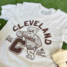 Designed and printed locally in Cleveland on a super soft heather dust unisex crewneck tee shirt with superior Airlume combed and ring-spun 100% cotton. *This product and its graphic design is not endorsed or licensed in any way by any team, or organization. SIZE BODY LENGTH CHEST WIDTH SLEEVE LENGTH CHEST TO FIT XS 27" 16.5" 8" 31"-34" S 28" 18" 8.25" 34"-37" M 29" 20" 8.625" 38"-41" L 30" 22" 9.5" 42"-45" XL 31" 24" 9.625" 46"-49" 2XL 32" 26" 10.25" 50"-53" 3XL 33" 28" 10.875" 54"-57" Retro Team Shirts, Varsity T-shirts, Vintage Sports Shirt, Sports Shirts Design, College Tshirt Designs, Basketball Team Shirts, Sports Merch, Retro Shirt Design, Basketball Uniforms Design