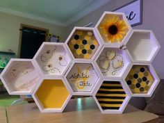 a bunch of hexagons with bees and sunflowers on them sitting on a table