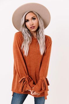 The coziest sweater has just arrived! Perfect for everyday, but with a hint of 'flare,' the pumpkin colored 'Winter Weather Shift Top' is everything you could want and more! This sweater features a split high-low hem, with more coverage in the back, ultra soft and stretchy fabric, and long sleeves that flare at the wrist and are accented by ties! Cozy Solid Tops For Fall, Brown Crew Neck Sweater For Fall, Casual Burnt Orange Tops For Fall, Orange Knit Tops For Fall, Burnt Orange Casual Tops For Fall, Brown Sweater For Fall Loungewear, Solid Sweater For Fall Loungewear, Burnt Orange Long Sleeve Top For Winter, Brown Fall Sweater For Loungewear