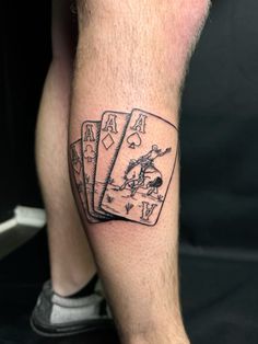 a man's leg with three playing cards tattoo on it