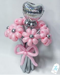 a bunch of balloons in the shape of flowers with a heart shaped balloon attached to it