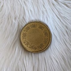 an antique gold pocket watch on white fur