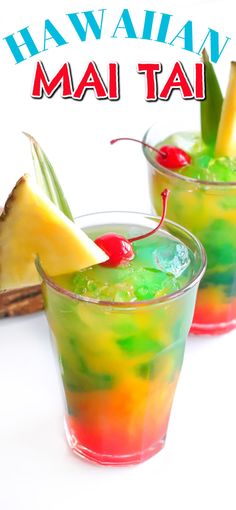 two glasses filled with different colored drinks and garnished with pineapples, cherries, and other fruit