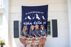 four girls are standing in front of a banner that says the adventure begins here, and there is an ad for camp adopt