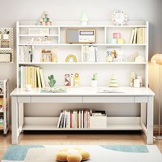 a white book shelf filled with lots of books next to a blue and white rug