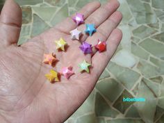 small colorful stars are in the palm of someone's hand