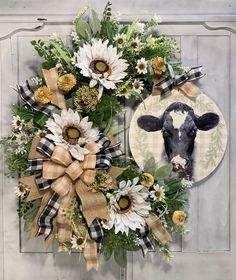 a wreath with a cow and flowers on it