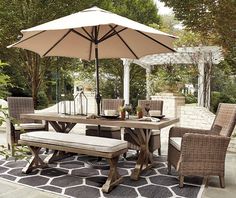 an outdoor dining set with umbrella and chairs