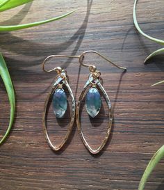 Moss Agate and 14k Gold Fill hoops. Hammered 14k gold fill, tumbled and polished to a high shine. 14k gold fill wrapped natural, faceted Moss Agate Briolettes. Semi transparent with green "moss" dendrites. Finished with 14k gold fill French hooks.  Measurements: 1 3/4" long and 5/8" wide.  Made in and shipped from Tupper Lake, New York. Gold Moss Agate Round Jewelry, Handmade Oval 14k Gold Filled Earrings, Green And Gold Jewelry, Moss Agate Crystal, Gold Filled Hoops, Earrings Green, Agate Crystal, Semi Transparent, Moss Agate