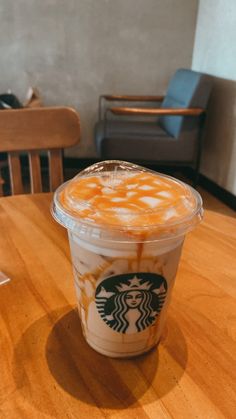 a starbucks drink sitting on top of a wooden table