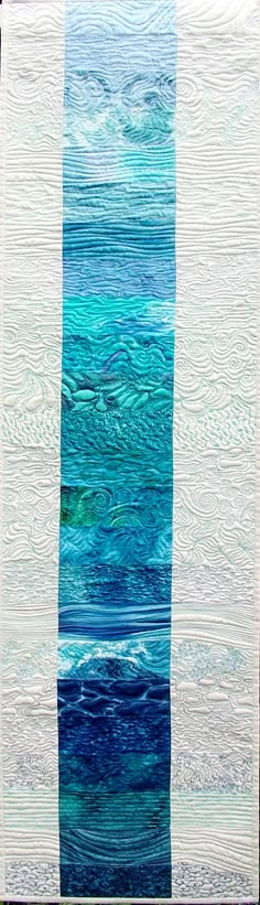 a blue and white quilt with waves on it