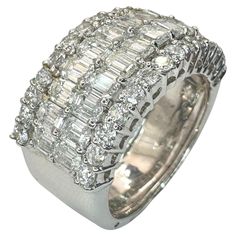 a white gold ring with baguetts and diamonds on the sides, set in 18k white gold