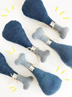 four pieces of denim dog bone ornaments on a white surface