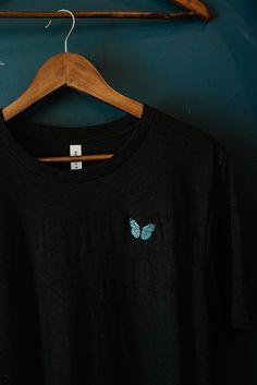 softest tee with the prettiest butterfly embroidery🦋 available on a beige or black tee in a variety of sizes. also available on a white or black sweatshirt! perfect to dress up or down. prefer a sweatshirt? click here: https://www.etsy.com/listing/821856421/butterfly-embroidery-sweatshirt?ref=reviews don't see the size or color you're looking for? contact me for restocks! specifications: -premium pre-shrunk t-shirts source is bella & canvas and is 100% no sweatshops & eco-friendly -90% Airlume combed and ring-spun cotton, 10% poly -comes in unisex sizing, swipe to last image for sizing guide -butterfly embroidery size is 29.2 mmx47 mm -to best maintain embroidery, wash cold & air dry -available to ship in 1-3 business days.  please don't hesitate to reach out if you have any questions🌸 t Cheap Embroidered Black T-shirt, Cheap Black T-shirt With Custom Embroidery, Most Beautiful Butterfly, Butterfly Embroidery, Embroidery Sweatshirt, Black Sweatshirt, Cozy Sweatshirts, White Sweatshirt, Black Tee