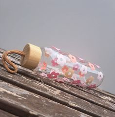 a water bottle sitting on top of a wooden table next to a string and rope