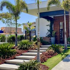 a house with lots of plants and trees in front of the entrance to the building