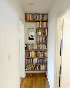 there is a bookshelf full of books in the hallway