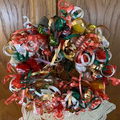 an arrangement of candy and ribbons in a basket on a doily next to a wooden door