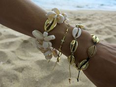 This beautiful cowrie set bracelet is made with natural white cowrie shells, natural gold cowrie shells, big 24k gold plated cowrie shell, freshwater pearls, 24k gold plated beads and beige silk cord. Bead size: shell 1,5 - 2 cm / 0,6 - 0,8 inch.; gold shell 2,5 cm/ 1 inch.; gold plated beads 0,3 cm /0,1 inch. Your bracelet comes gift wrapped and shipped via priority registered air mail with tracking info available. Feel free to ask me any questions! Thanks for visiting and happy shopping :) Gold Shell Bracelets For Gift, Gold Shell Bracelets For Gifts, Adjustable Gold Shell-shaped Bracelet, Gold Shell Beaded Bracelets As Gift, Bohemian Gold Beaded Bracelets With Shell, Gold Beaded Bracelets For Summer Beach, Bohemian Gold Beaded Shell Bracelets, Summer Gold Beaded Bracelets For Beach, Summer Beach Gold Beaded Bracelets