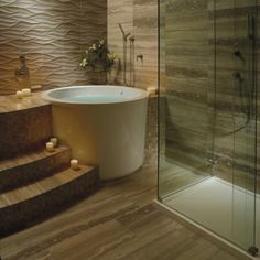 a bath tub sitting next to a walk in shower and a wooden steps leading up to it