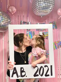 a mother and daughter kissing each other in front of a photo frame that says ab 2021