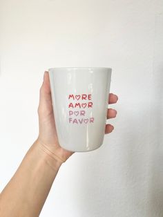 a hand holding a coffee mug with the words more amr por flavor written on it