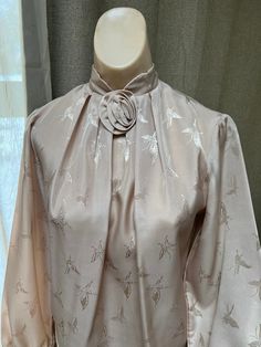 "Pretty sand color dressy blouse is perfect for a professional lady or one part of a formal outfit paired with a dressy skirt or slacks.  No tags of any kind so I am not certain about the size or the fabric.   But I am pretty sure the fabric is a very nice polyester with a matte satin surface.  From the way it fits my size S dress form I would recommend it for a lady who usually wears a size 4 or 6 in a top. Everything about the fabric - texture, color, embossed design - is lovely.  The color is Beige Feminine Formal Tops, Beige Formal Feminine Tops, Formal Feminine Beige Tops, Elegant Formal Tops For Spring, Elegant Spring Wedding Blouse, Fitted Solid Color Elegant Blouse, Elegant Spring Blouse For Formal Occasions, Elegant Fitted Blouse, Elegant Formal Blouse For Spring