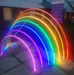 an arch made out of neon lights on the sidewalk