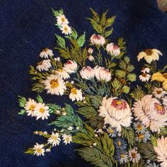 a bunch of flowers that are sitting on a blue table cloth with some scissors in it