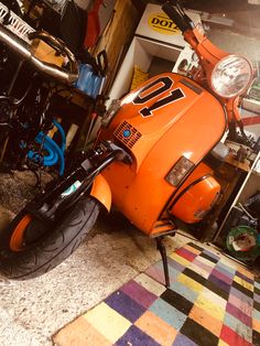 an orange motorcycle is parked in a garage