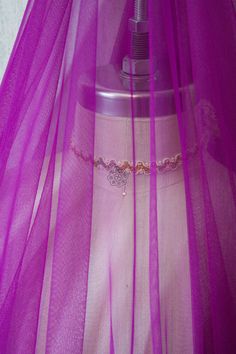 a mannequin wearing a purple veil with a necklace on it's neck