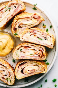 ham and cheese sandwiches on a plate with mustard spread in the middle, ready to be eaten