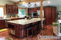 a large kitchen with wooden floors and lots of counter space, including an island in the middle