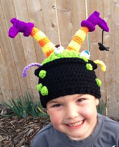 a young boy wearing a crocheted hat with horns