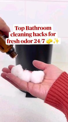 someone is cleaning their bathroom with the help of a bottle and some cotton balls in front of them