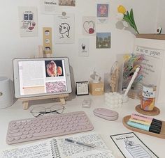 a desk with a computer, keyboard and various office supplies