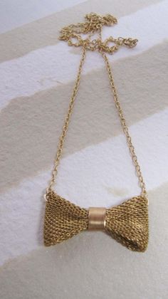 "Lovely gold, mesh, bow necklace. The bow is vintage with a new 14K Gold Filled chain. We have two sizes of bows. We have approx a 2\" bow and a 1\" bow. The model is wearing the 1\" bow. 16\" Length. --Shop Policies-- Please be sure to read our shop policies before making your purchase. Thank you! https://www.etsy.com/shop/diamentdesigns/policy" Gold Bow Necklace For Party, Gold Necklace With Bow For Party, Gold Necklace With Decorative Bow For Party, Formal Gold Necklaces With Ribbon, Formal Gold Ribbon Necklace, Formal Gold Necklace With Ribbon, Gold Ribbon Necklace For Wedding, Vintage Gold Jewelry With Ribbon, Vintage Gold Jewelry With Decorative Bow