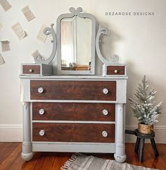 a dresser with drawers and a mirror on top of it next to a christmas tree